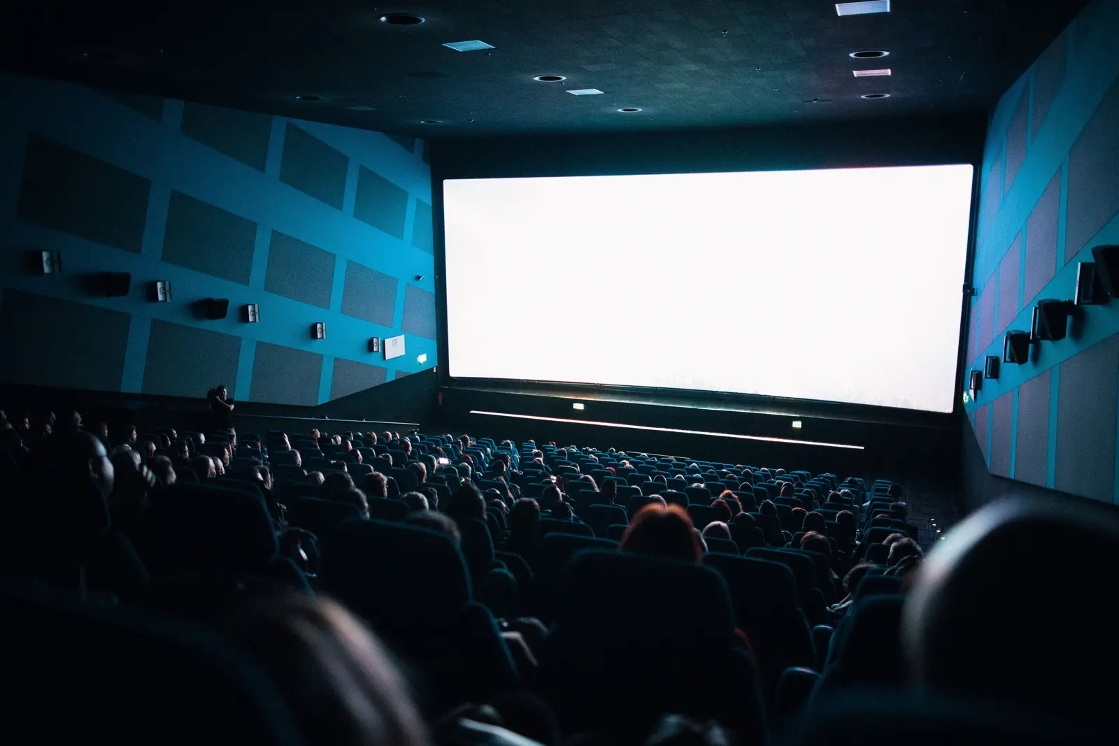 A full cinema audience watching a large movie screen
