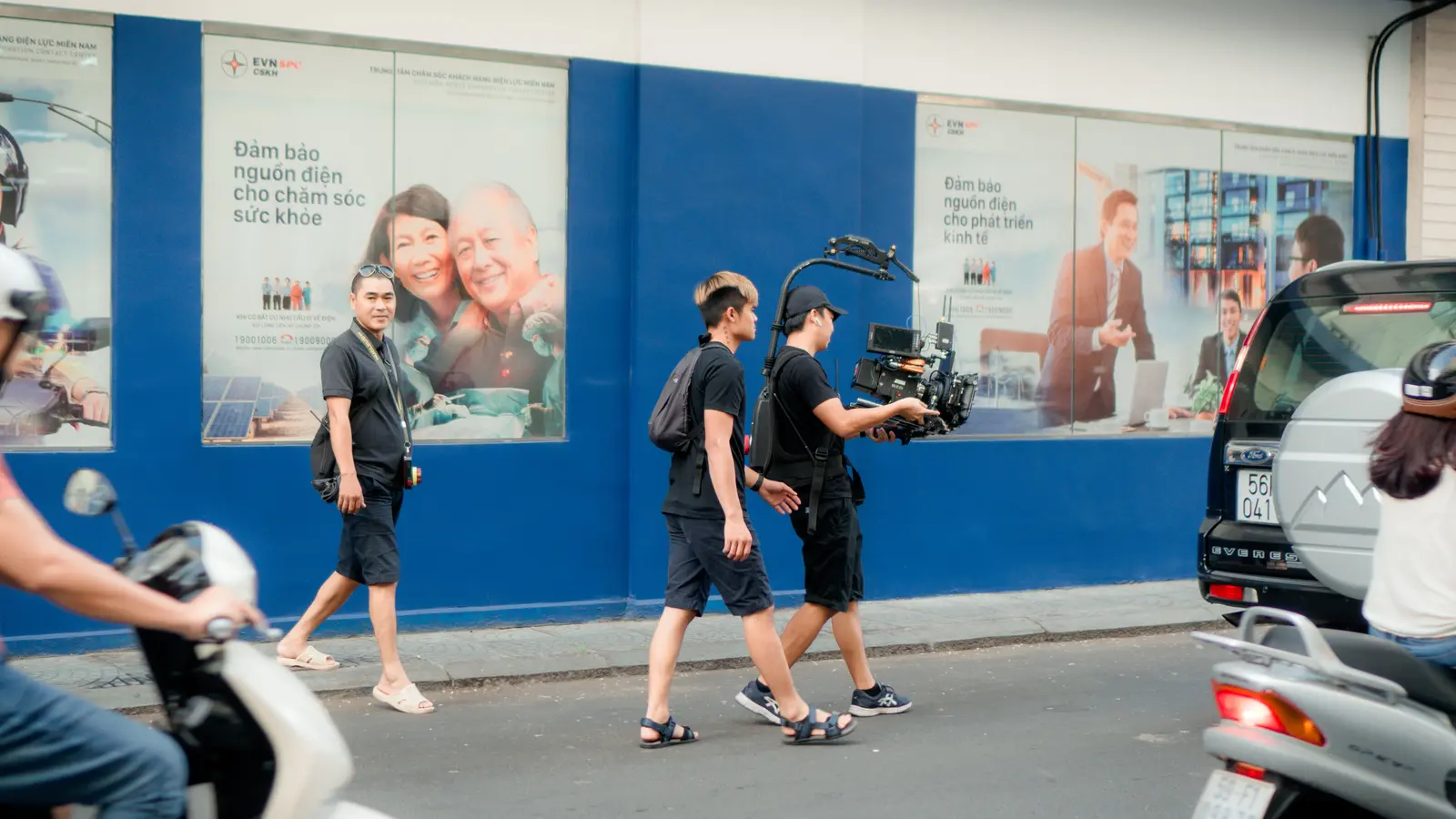 A documentary-style camera crew filming on a city street
